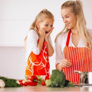 girl excited for dinner watching mom cooking